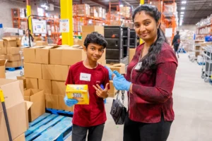 Smiling warehouse volunteers in the Food Banks Mississauga warehouse